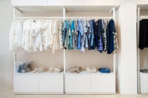 white and blue shirts hanging on white wooden cabinet