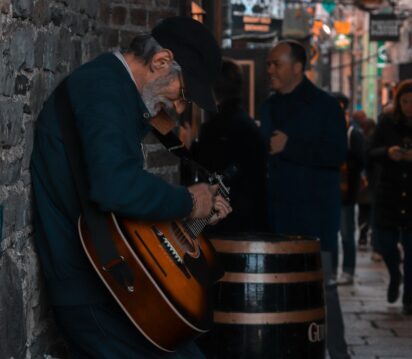 man playing guitar on street